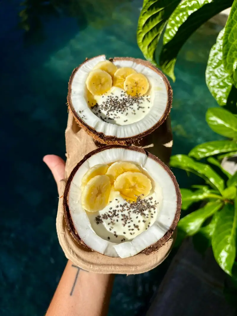 Bowls de yaourt, banane et graines de chia servis dans des noix de coco fraîches — brunch à l'Île Maurice