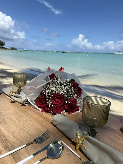 Bouquet de roses rouges sur une table dressée face au lagon pour une demande en mariage à l'Île Maurice